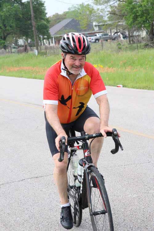 Vibrant cyclist riding on a scenic road during Bluebonnet Express event, showcasing outdoor cycling and adventure.