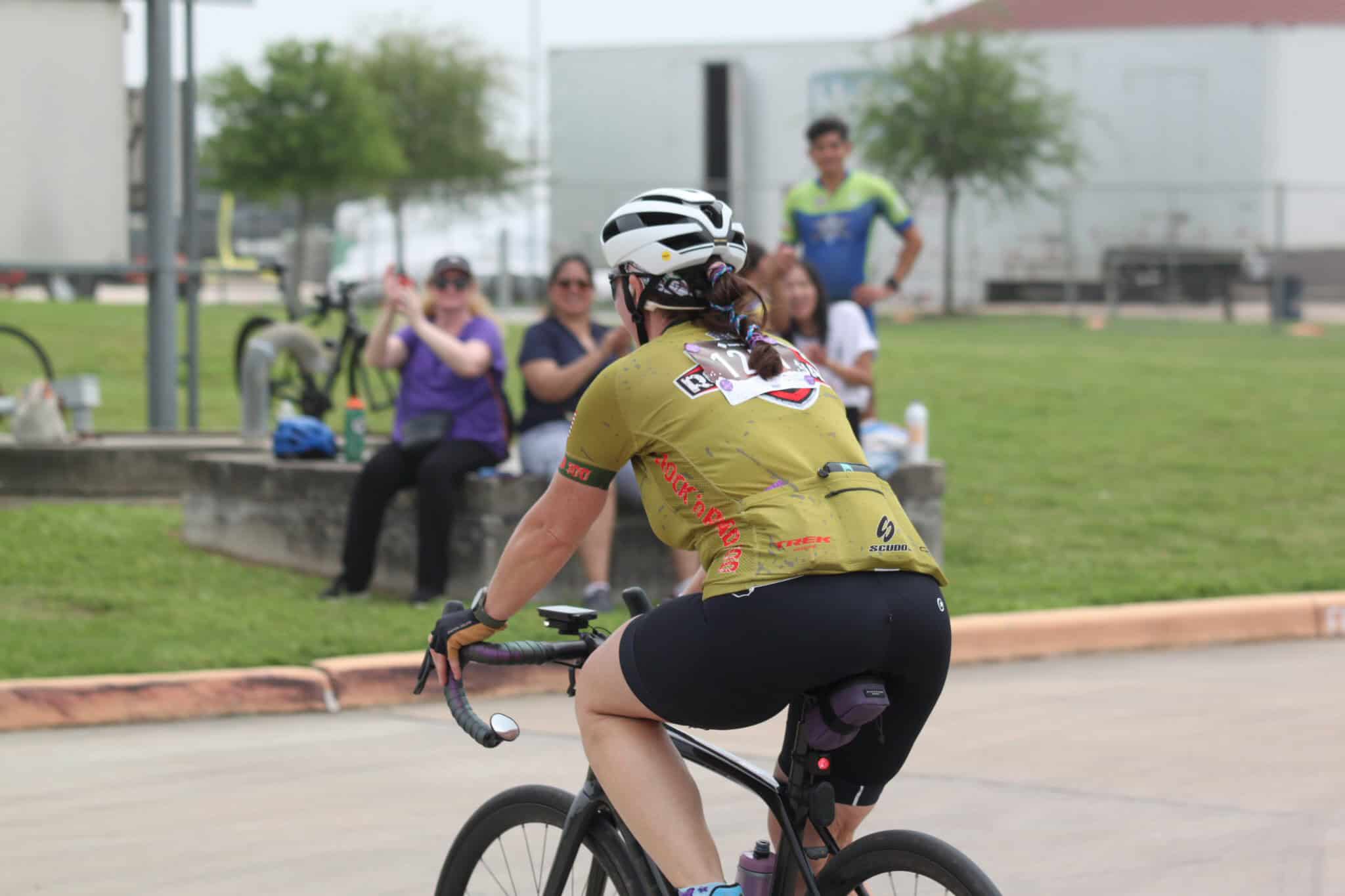 Cyclist riding in Bluebonnet Express cycling event with cheering spectators.