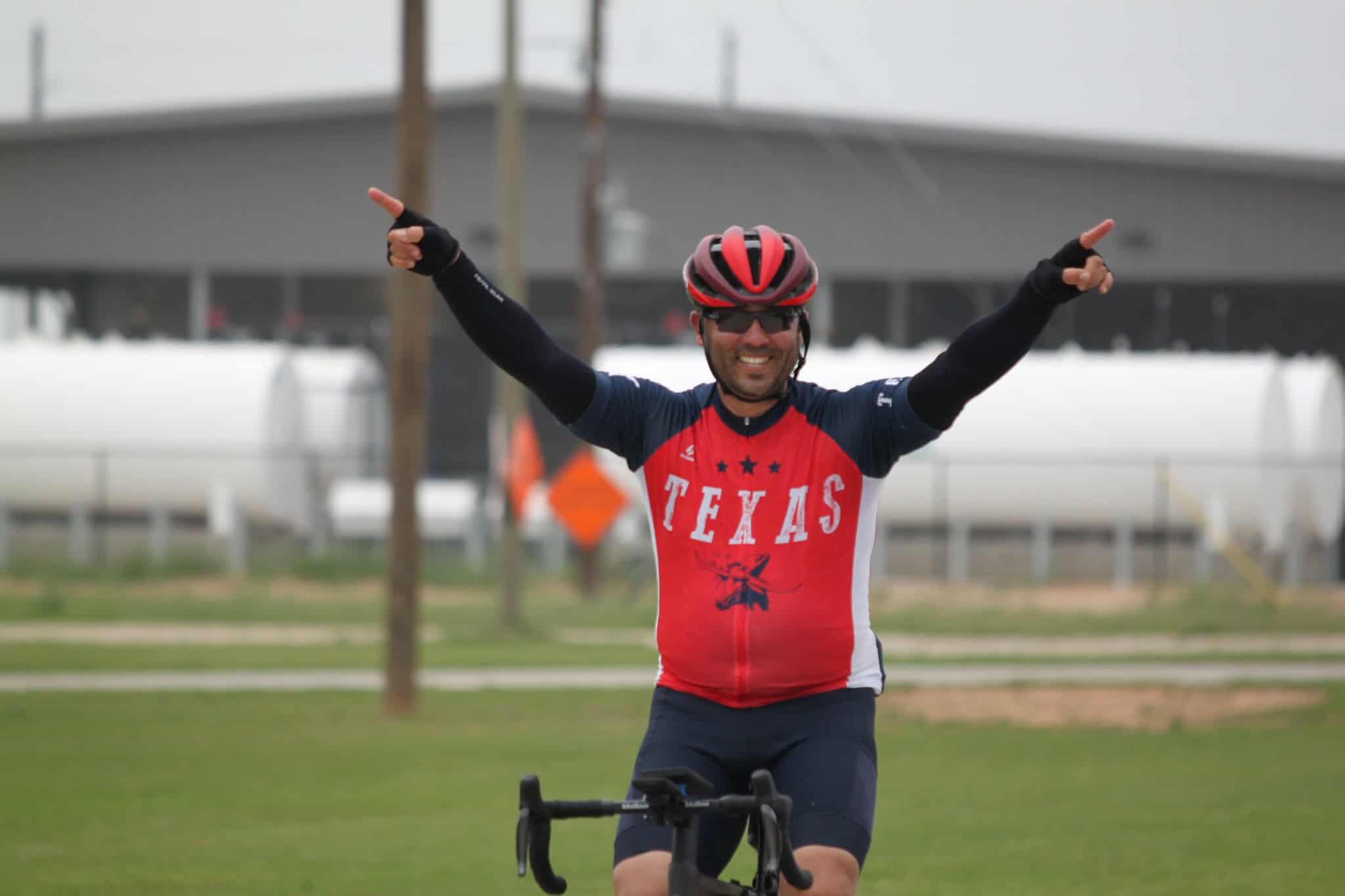 Vibrant cyclist celebrating victory on Bluebonnet Express bike trail, Texas cycling adventure, outdoor sports.