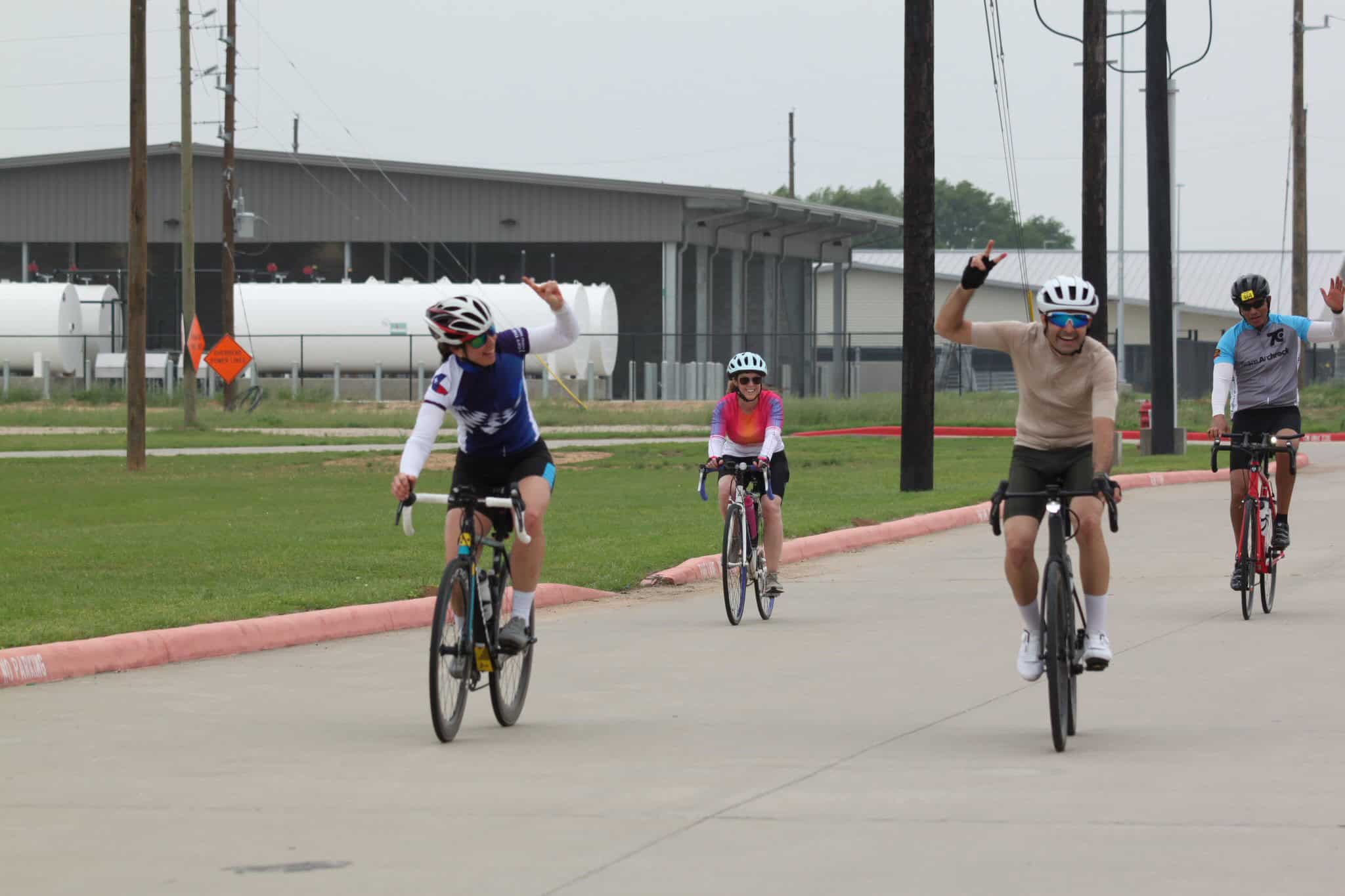 Bright group of cyclists enjoying a bike ride on a cloudy day, promoting Bluebonnet Express cycling event.