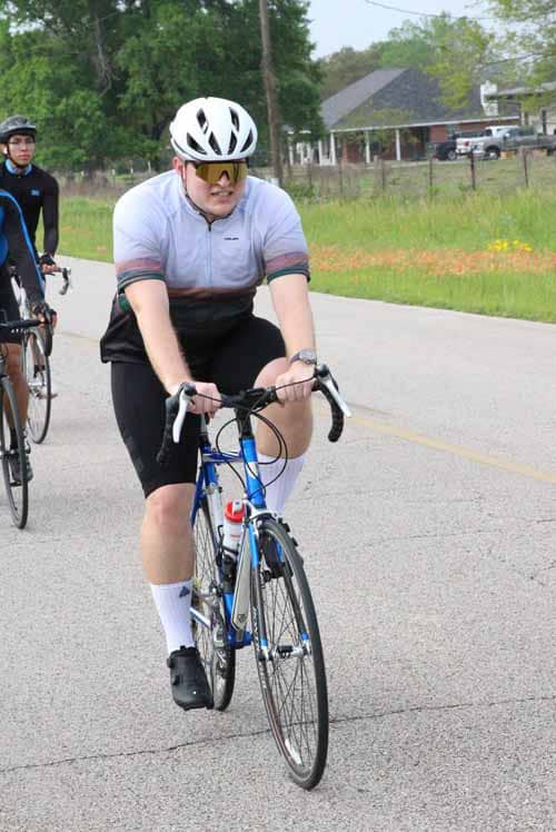 Bright yellow helmet and sunglasses cycling on road, Bluebonnet Express event, Texas outdoor bike ride, cyclist enjoying scenic ride.