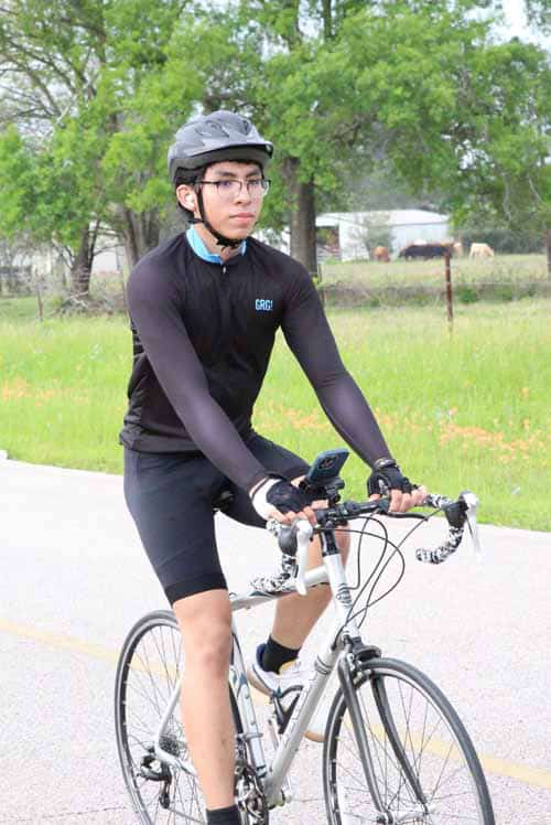 Youth cyclist riding a bluebonnet express themed bike outdoors.