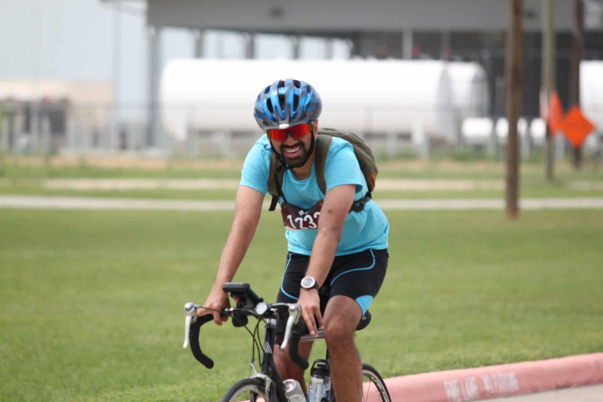 Vibrant cyclist enjoying a ride on a sunny day, promoting Bluebonnet Express bike services and scenic biking tours.