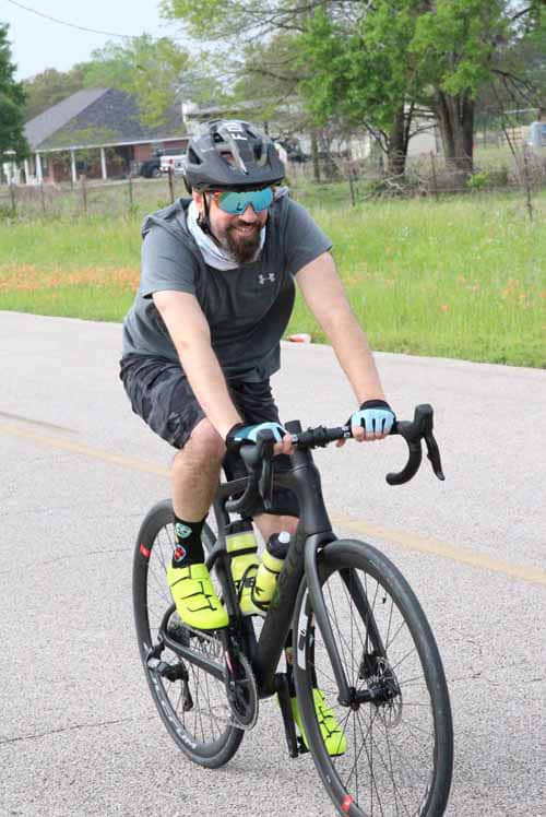 1. Man riding a road bike with helmet and sunglasses for cycling safety and fitness.