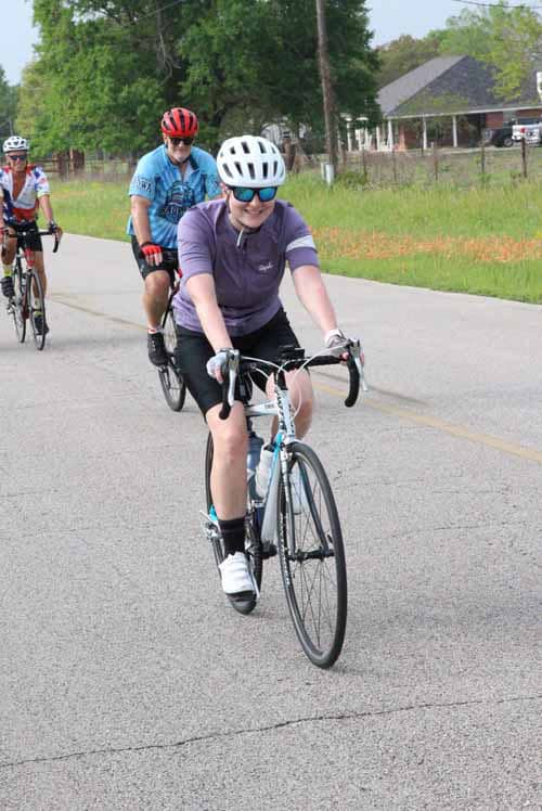 - Cyclists riding on a rural road during Bluebonnet Express event.