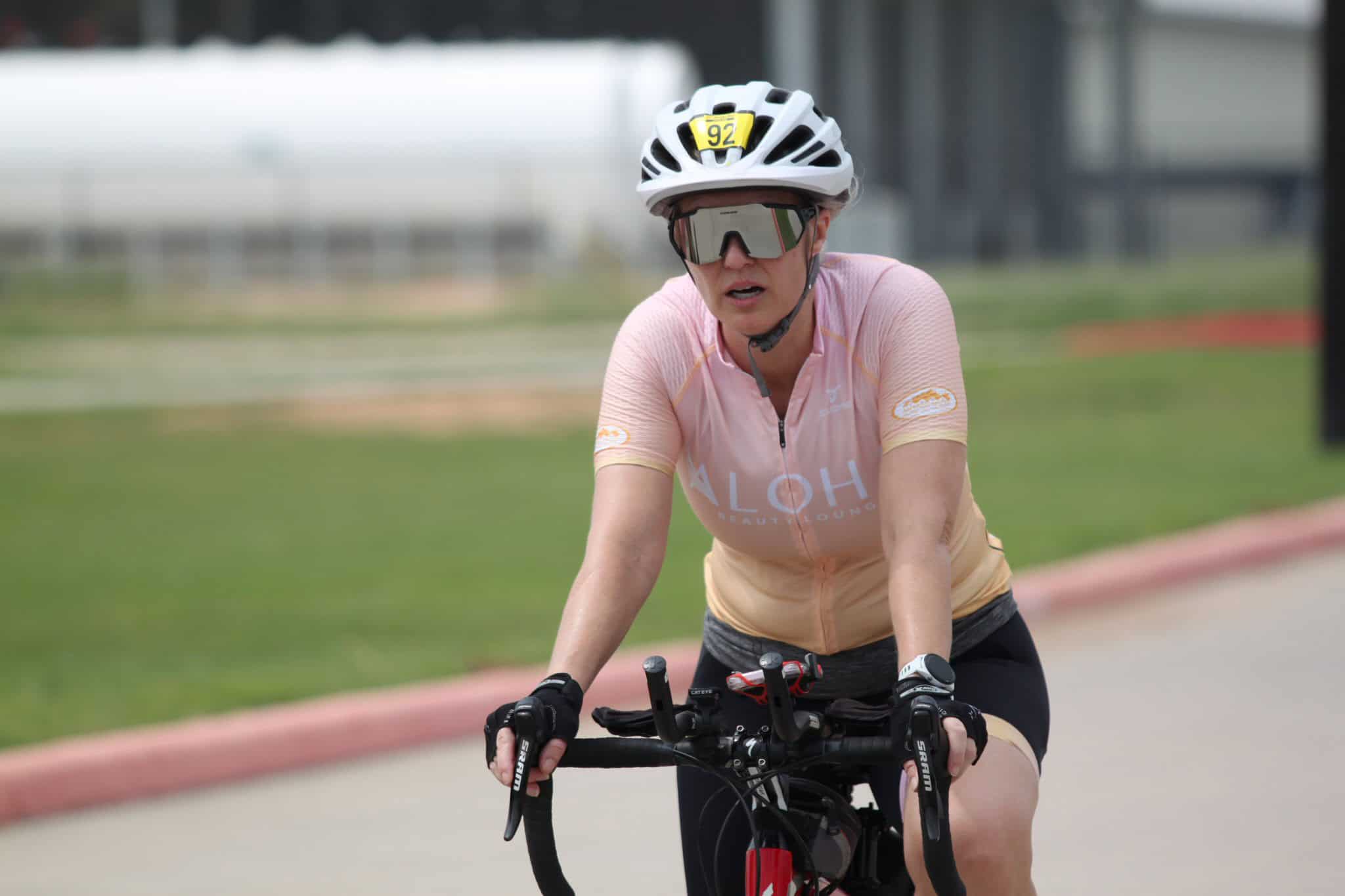 MidAdultFemaleCyclist wearing helmet and sunglasses on mountain bike during Bluebonnet Express event.
