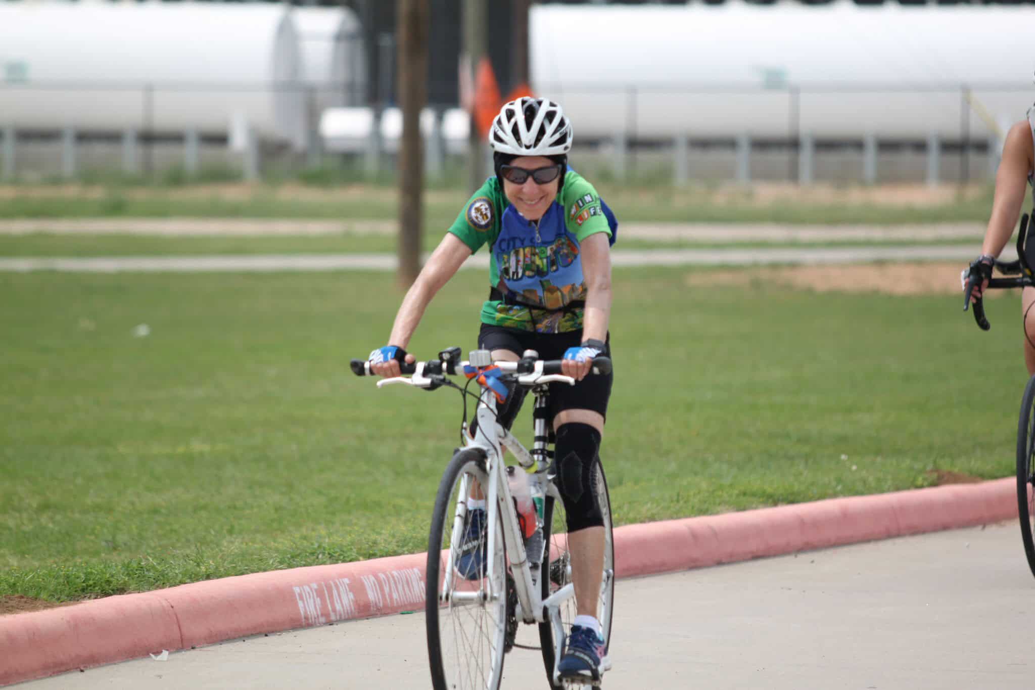 Bike rider on a scenic outdoor trail, promoting Bluebonnet Express bicycle transportation services.
