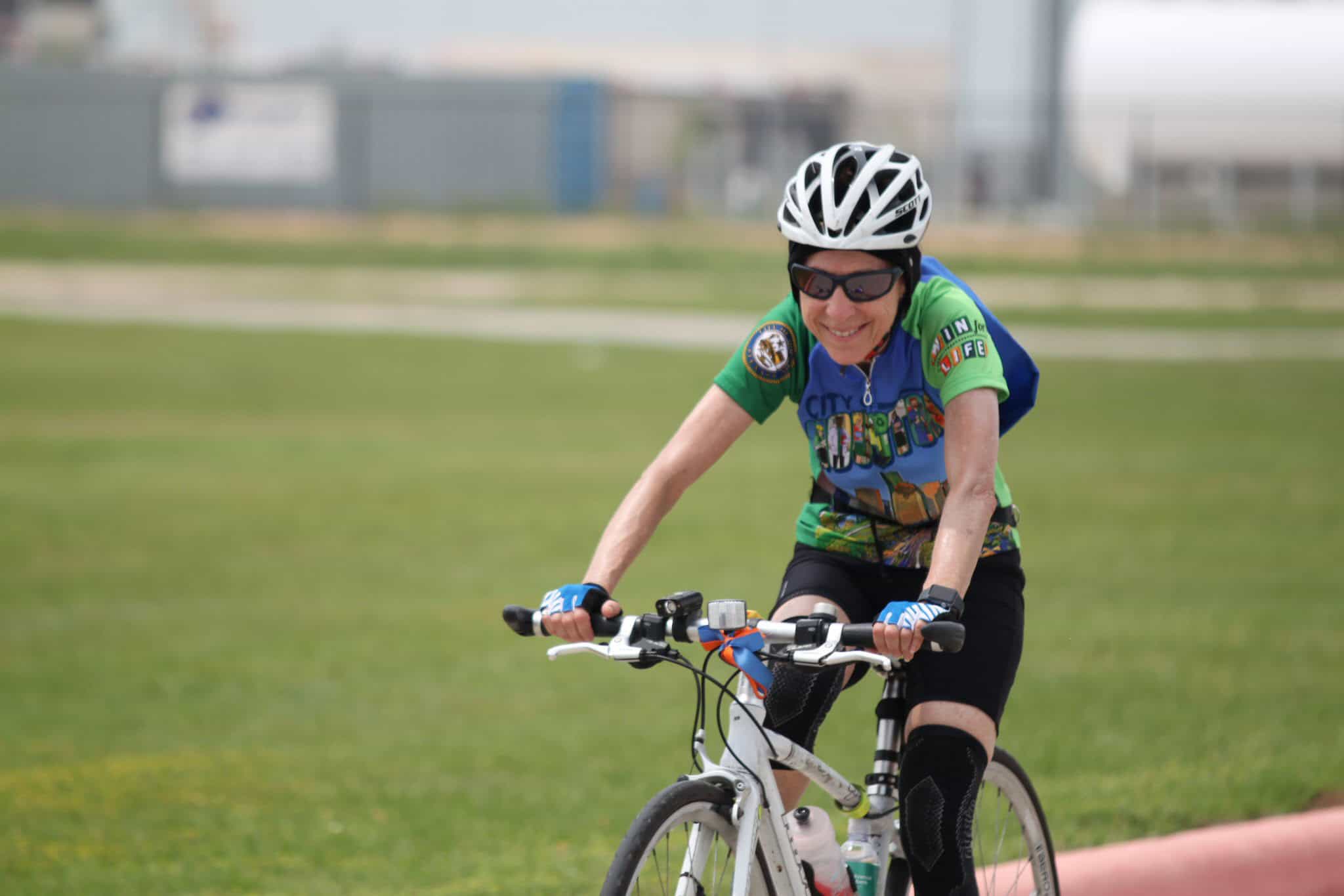 Vibrant cyclist riding mountain bike wearing gear on a sunny day in a park.