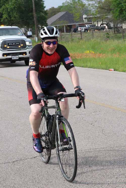 Bright cyclist riding on a road during Bluebonnet Express event in Texas.