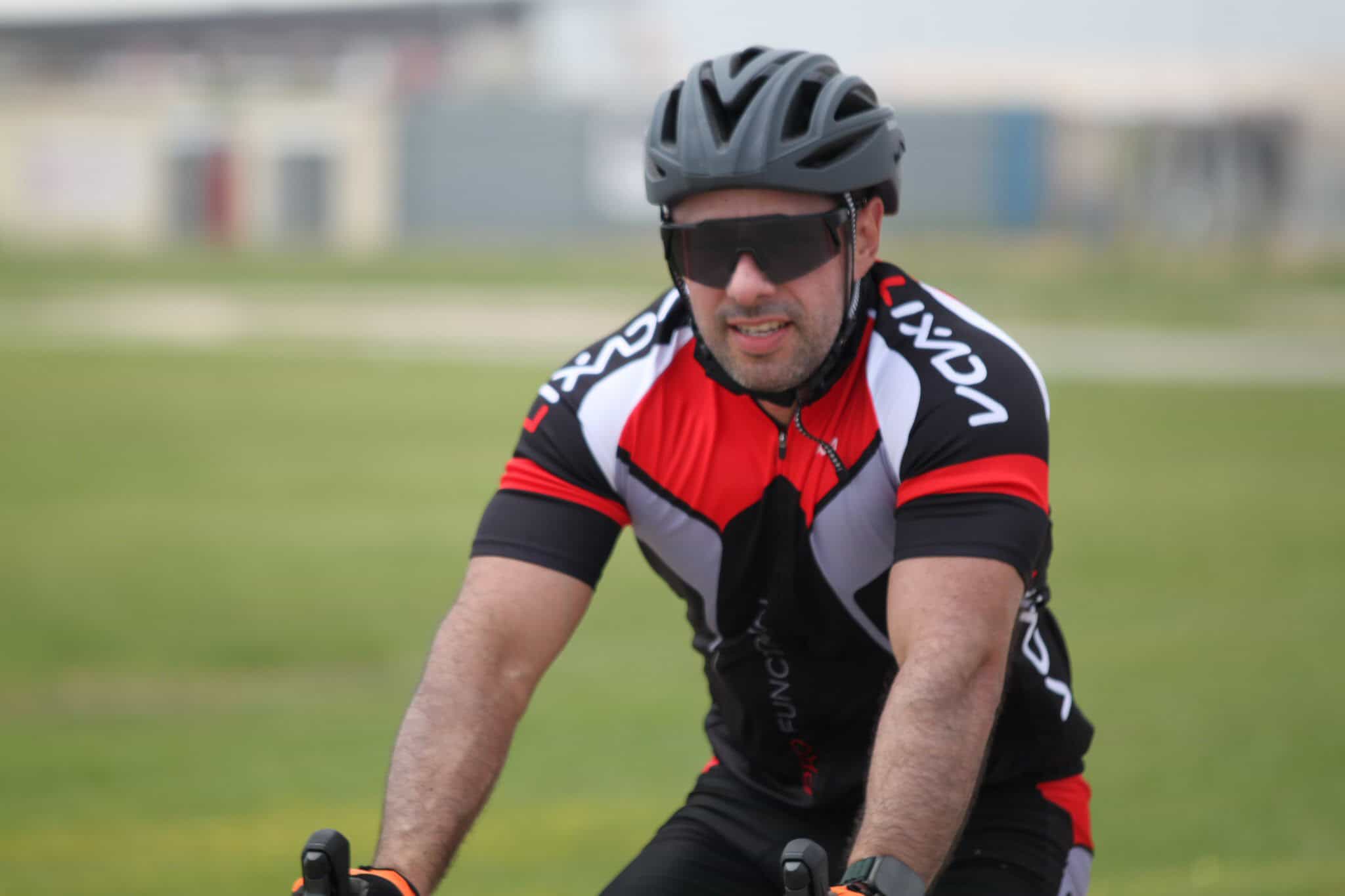 Cyclist wearing a helmet and sports gear riding outdoors with bluebonnet express branding strategy.