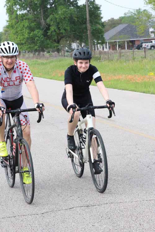 Children biking on a countryside road, promoting Bluebonnet Express cycling event.