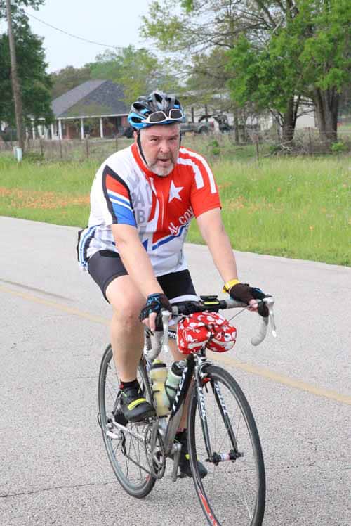 High-quality cyclist riding on a rural road during Bluebonnet Express event.