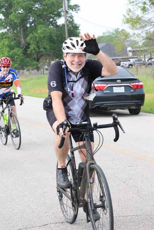 Happy cyclist waving during Bluebonnet Express bike ride event.