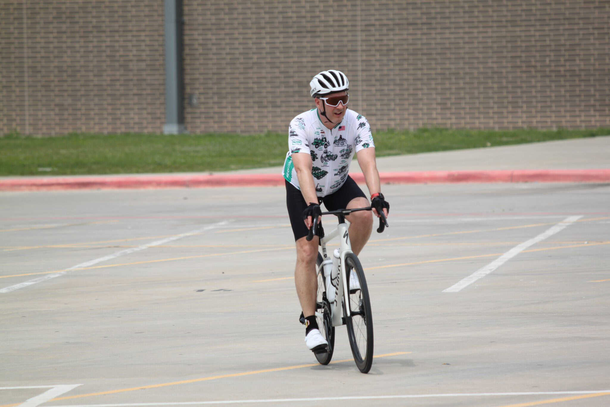 Vibrant cyclist riding bike in parking lot, promoting Bluebonnet Express bike transportation service.