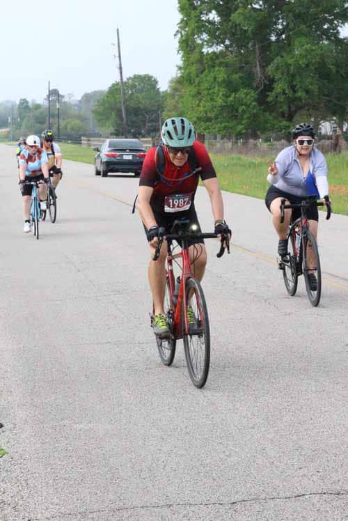 Cyclists riding during Bluebonnet Express event on a scenic road.
