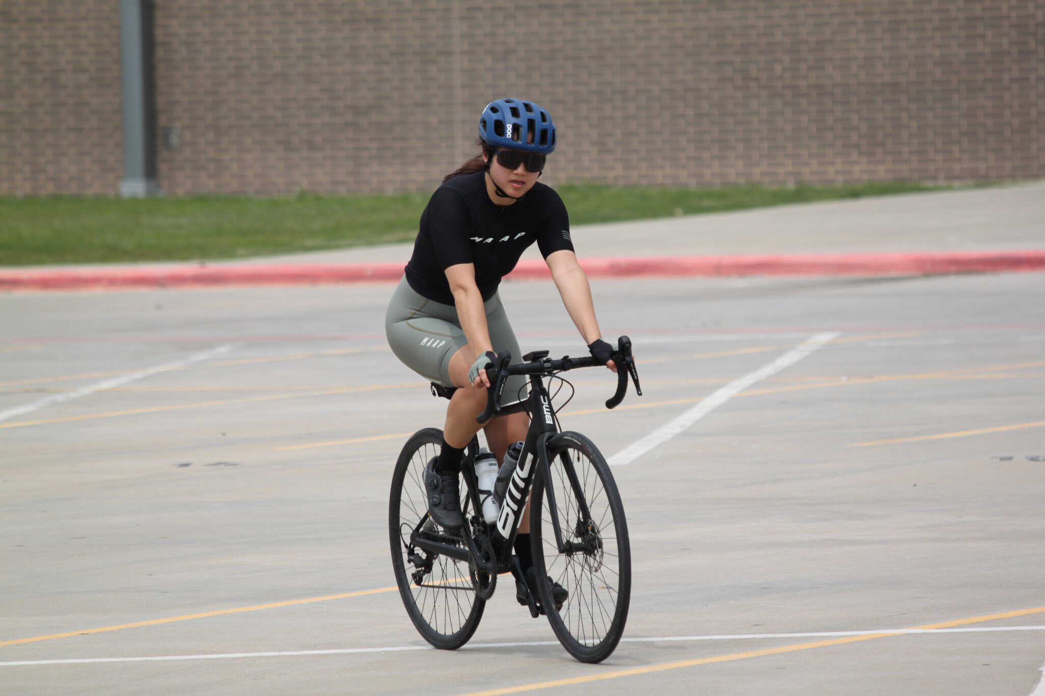 Fast women riding BMC road bike in parking lot for Bluebonnet Express cycling event.