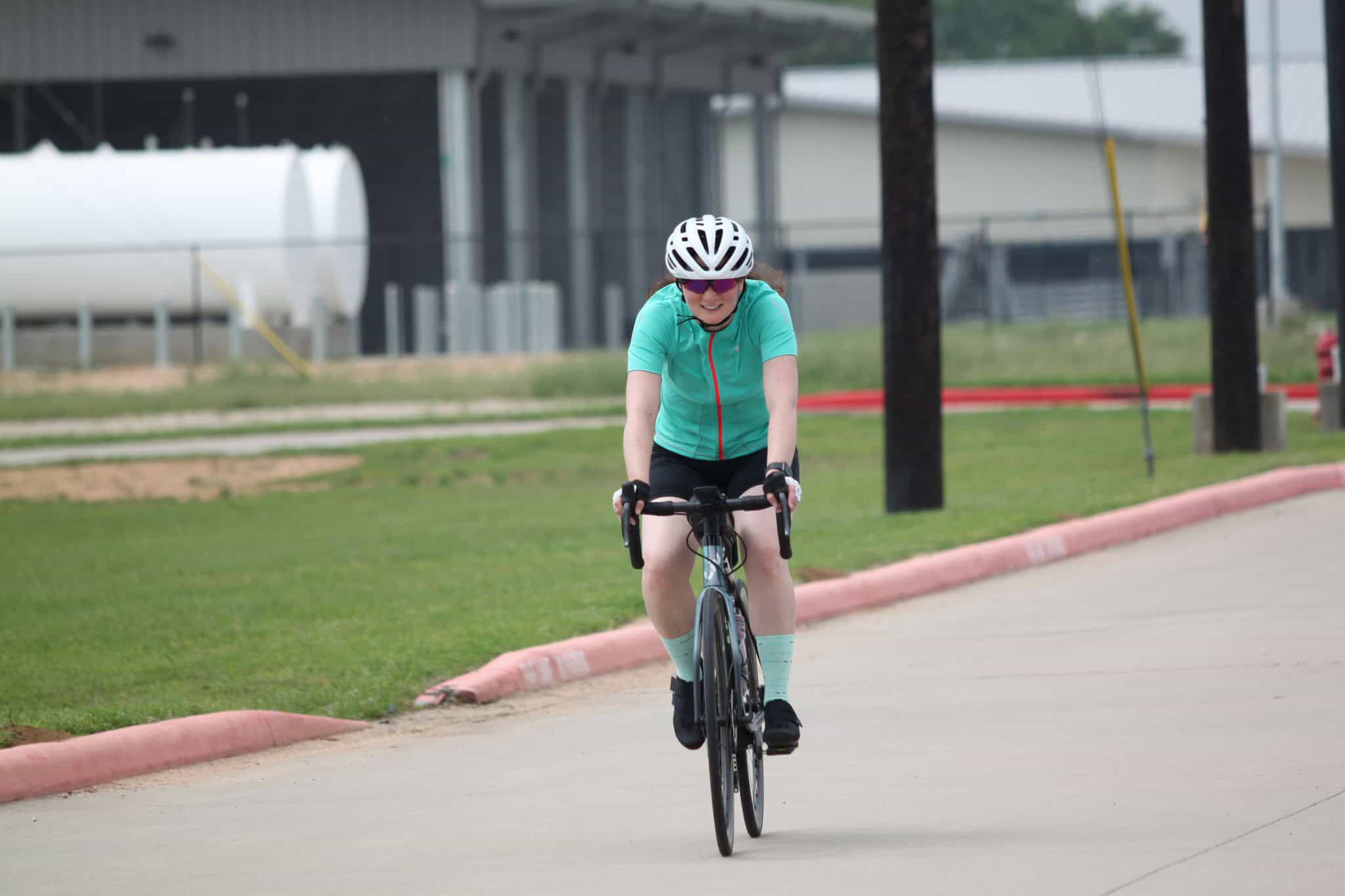 Bright female cyclist enjoying a ride on a sunny day with Bluebonnet Express bike route.