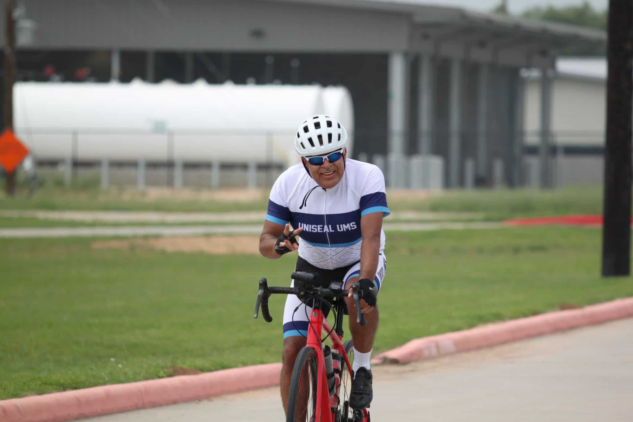 Bicycle rider wearing UNISEAL UMS jersey on Bluebonnet Express bike trail.