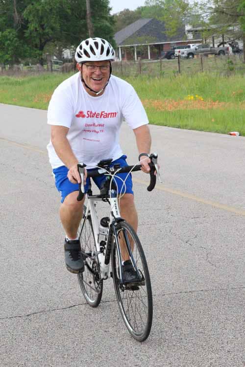 Bright smiling man cycling on street, Bluebonnet Express event, outdoor biking, community cycling, Texas road ride, healthy lifestyle.