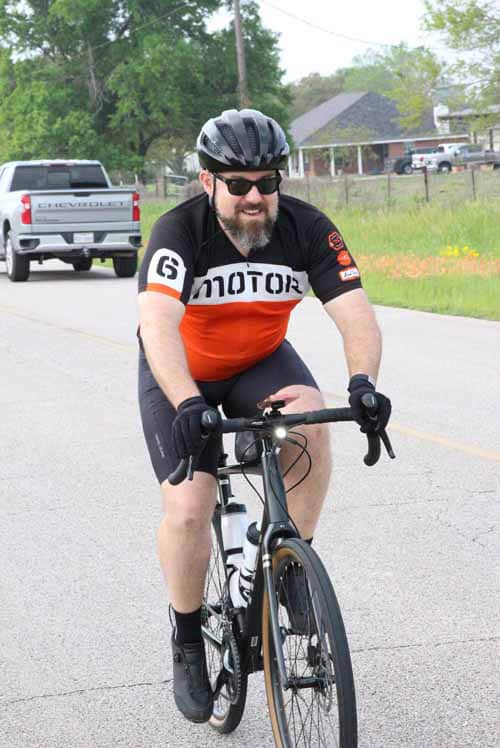 Rider wearing helmet on road bike during Bluebonnet Express event.