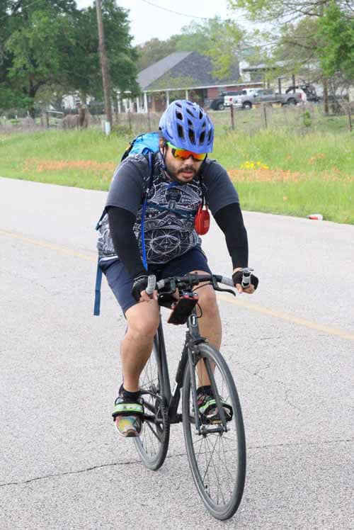 Fast cycling on the road with rider wearing helmet and sports gear for outdoor biking.