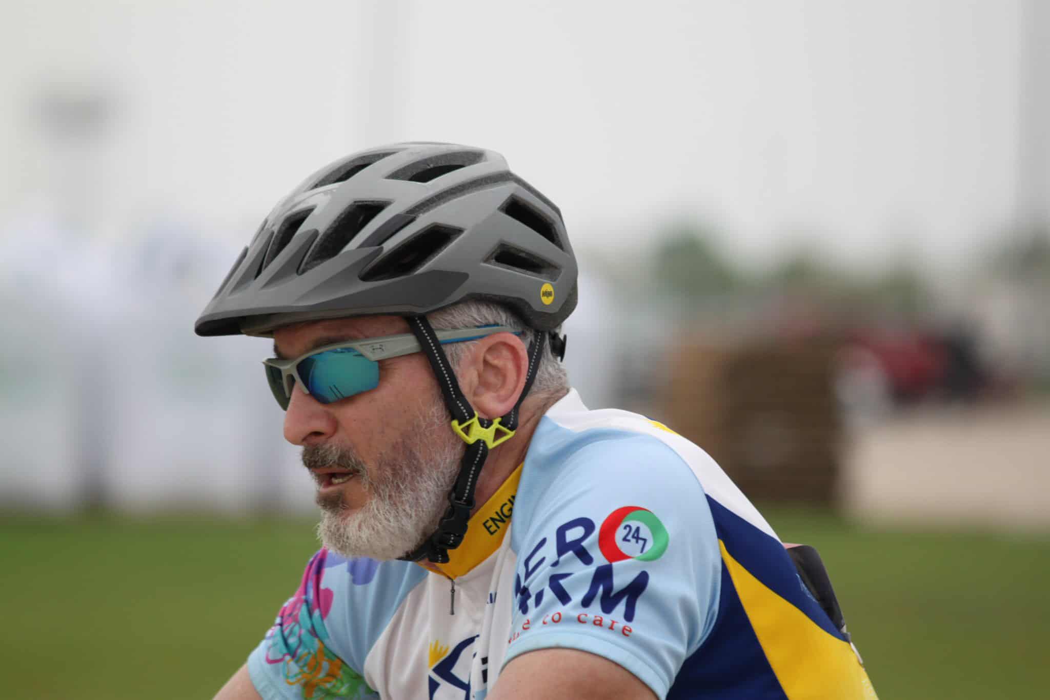 High-performance cyclist wearing helmet and sunglasses at Bluebonnet Express event, promoting eco-friendly biking.