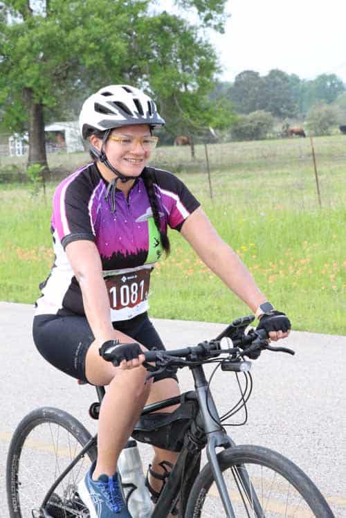 Active female cyclist enjoying a ride outdoors on a sunny day at Bluebonnet Express.