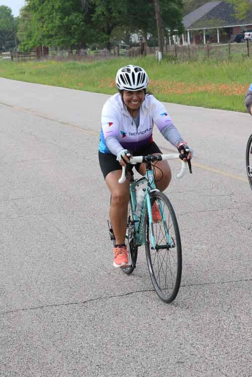 Bright woman cyclist enjoying Bluebonnet Express biking event on scenic rural road.