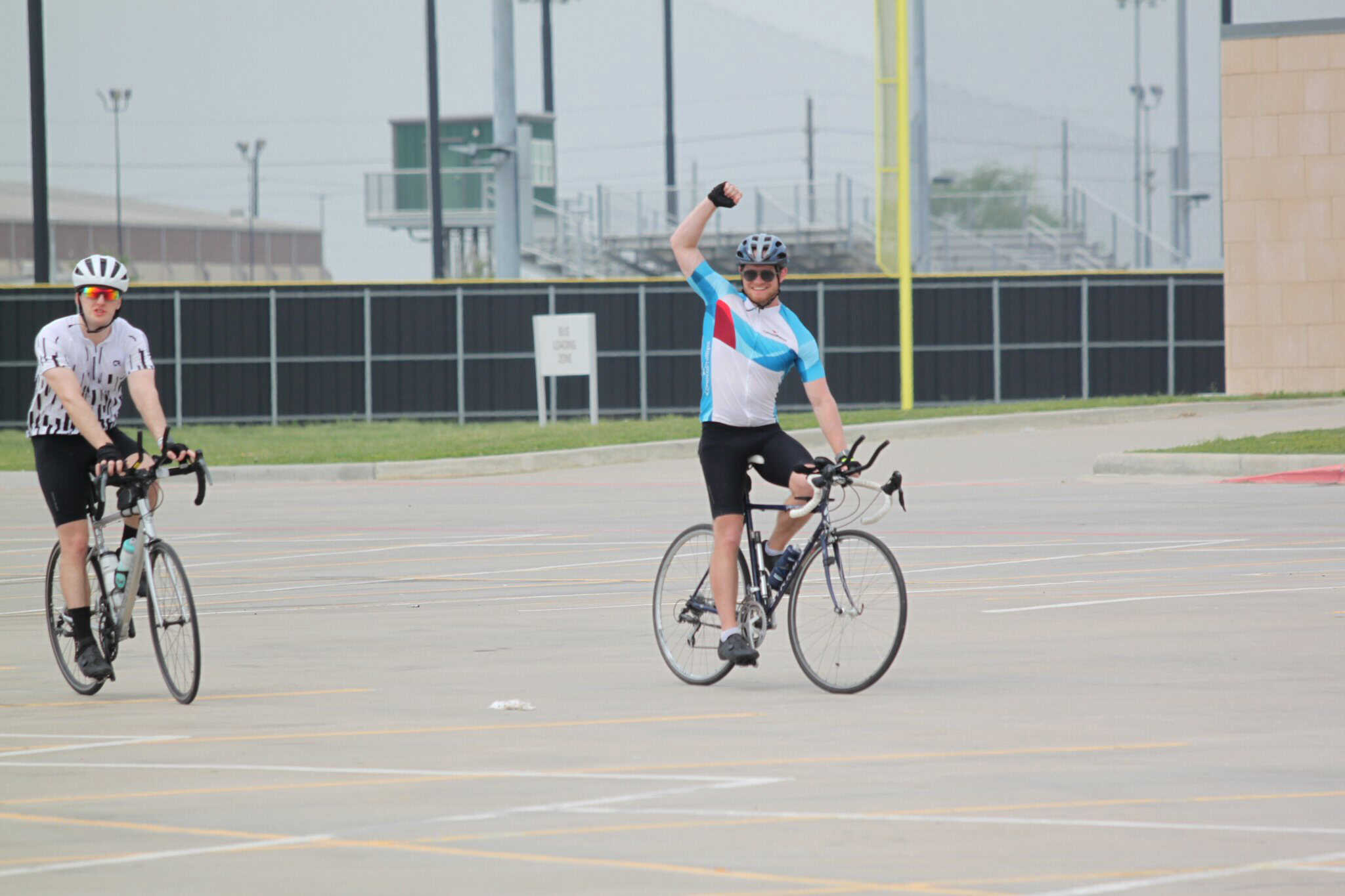 Vibrant cyclists celebrating during Bluebonnet Express bike event in an outdoor parking lot.