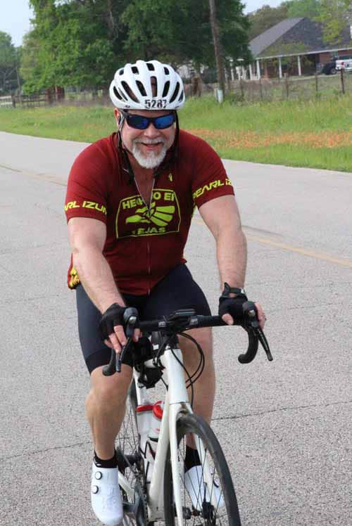 Bright cyclist on a road bike enjoying Bluebonnet Express ride in scenic Texas countryside.
