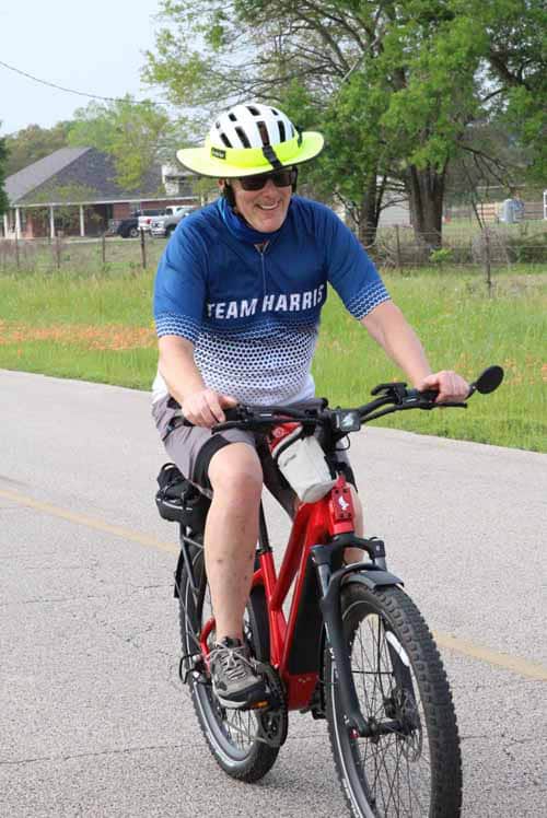 1. Woman riding a red electric bike wearing a helmet and sunglasses during daytime.