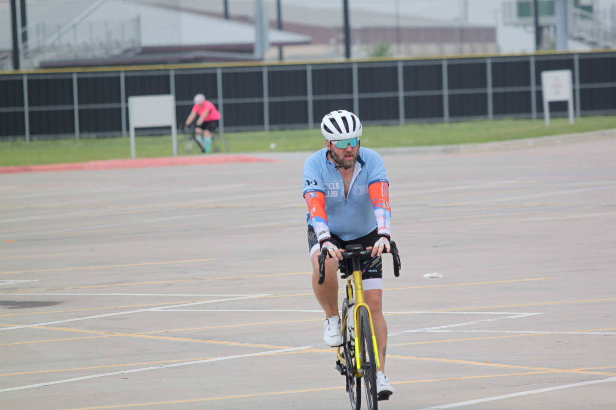 High-performance cyclist riding a Yellow Bike in a parking lot during Bluebonnet Express event.