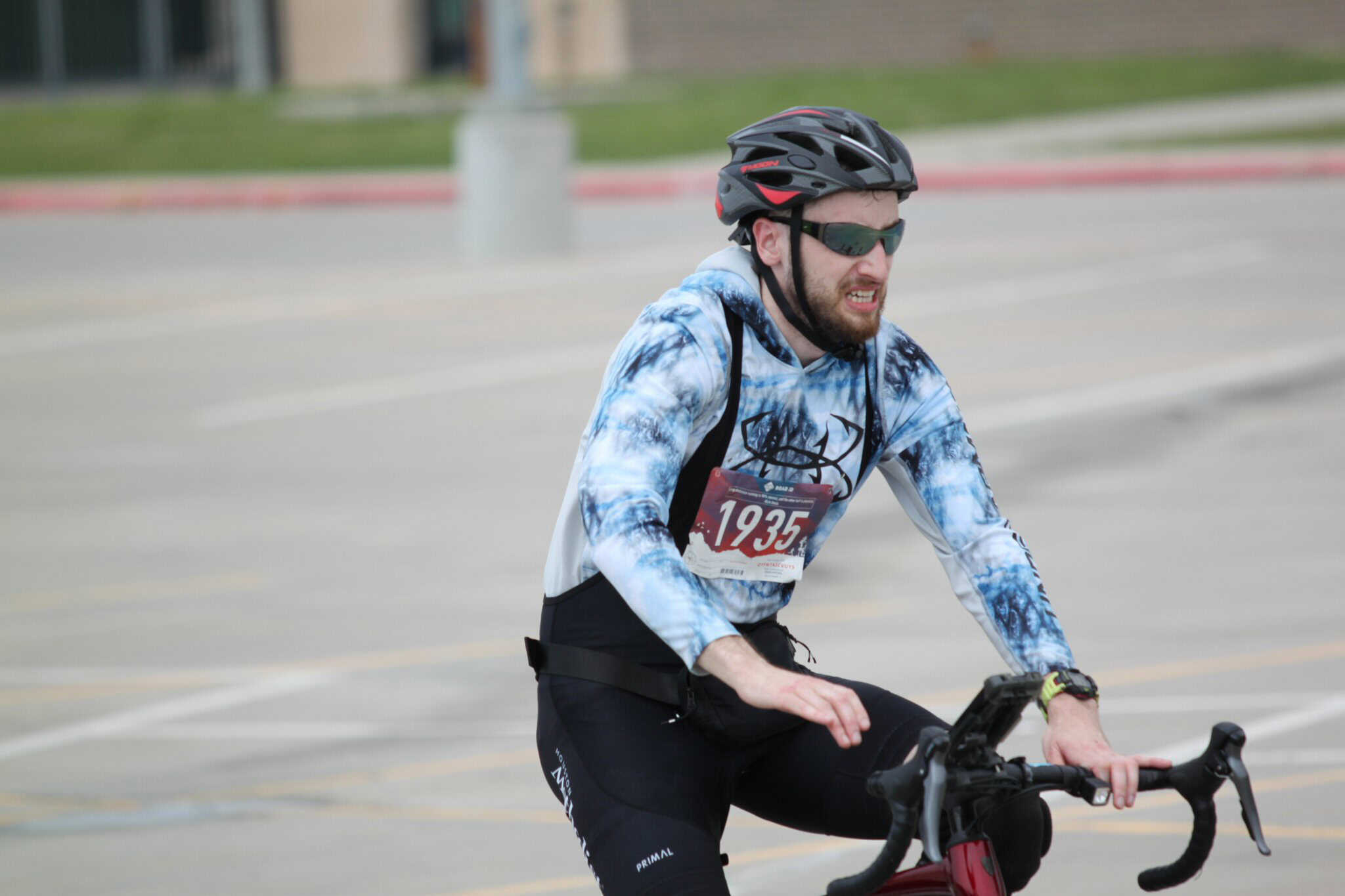 Cyclist wearing helmet and sunglasses participating in Bluebonnet Express bike race.