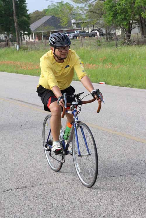 Young man riding a bicycle on the road during daytime.
