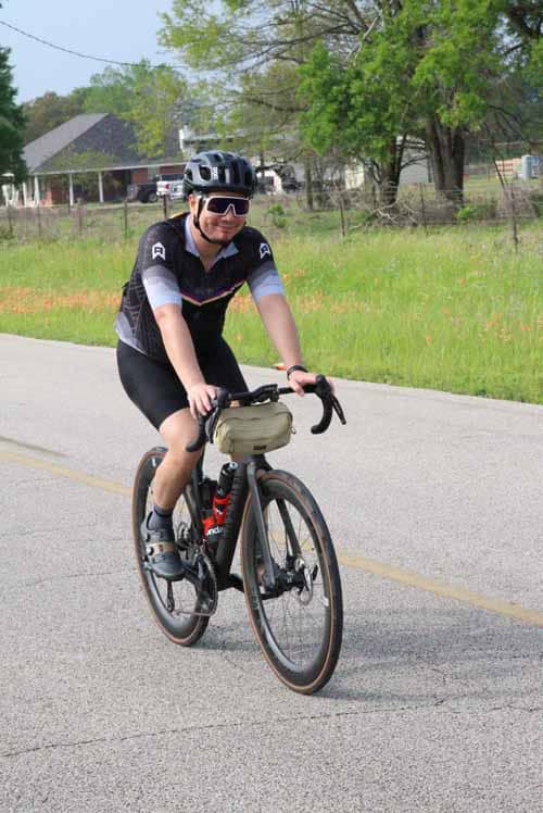 Bright cyclist enjoying a ride on a scenic road during daytime.