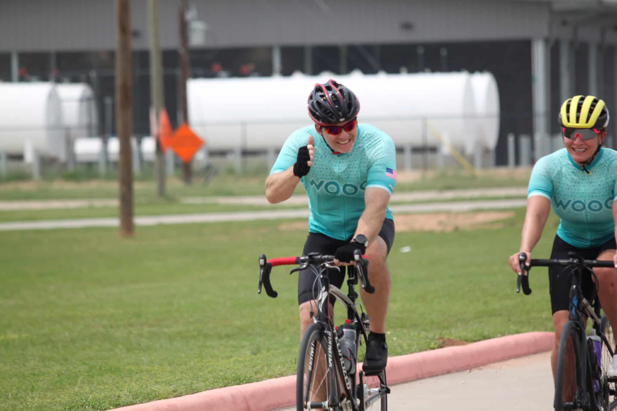 Vibrant cyclists riding on a green trail during Bluebonnet Express event.