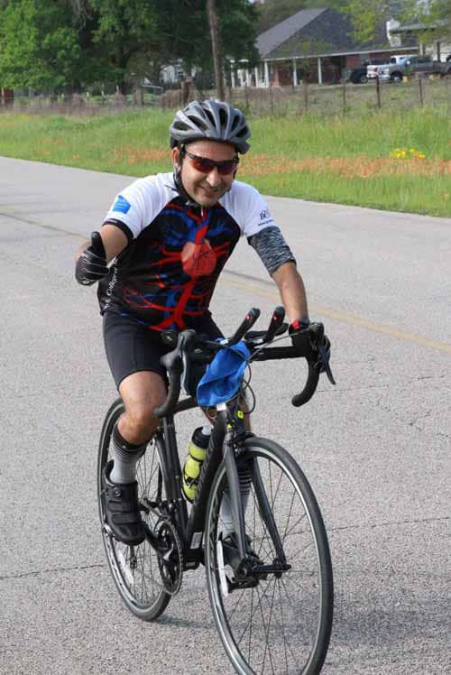 Bright male cyclist enjoying Bluebonnet Express bike ride on scenic Texas route, wearing helmet and sports gear.