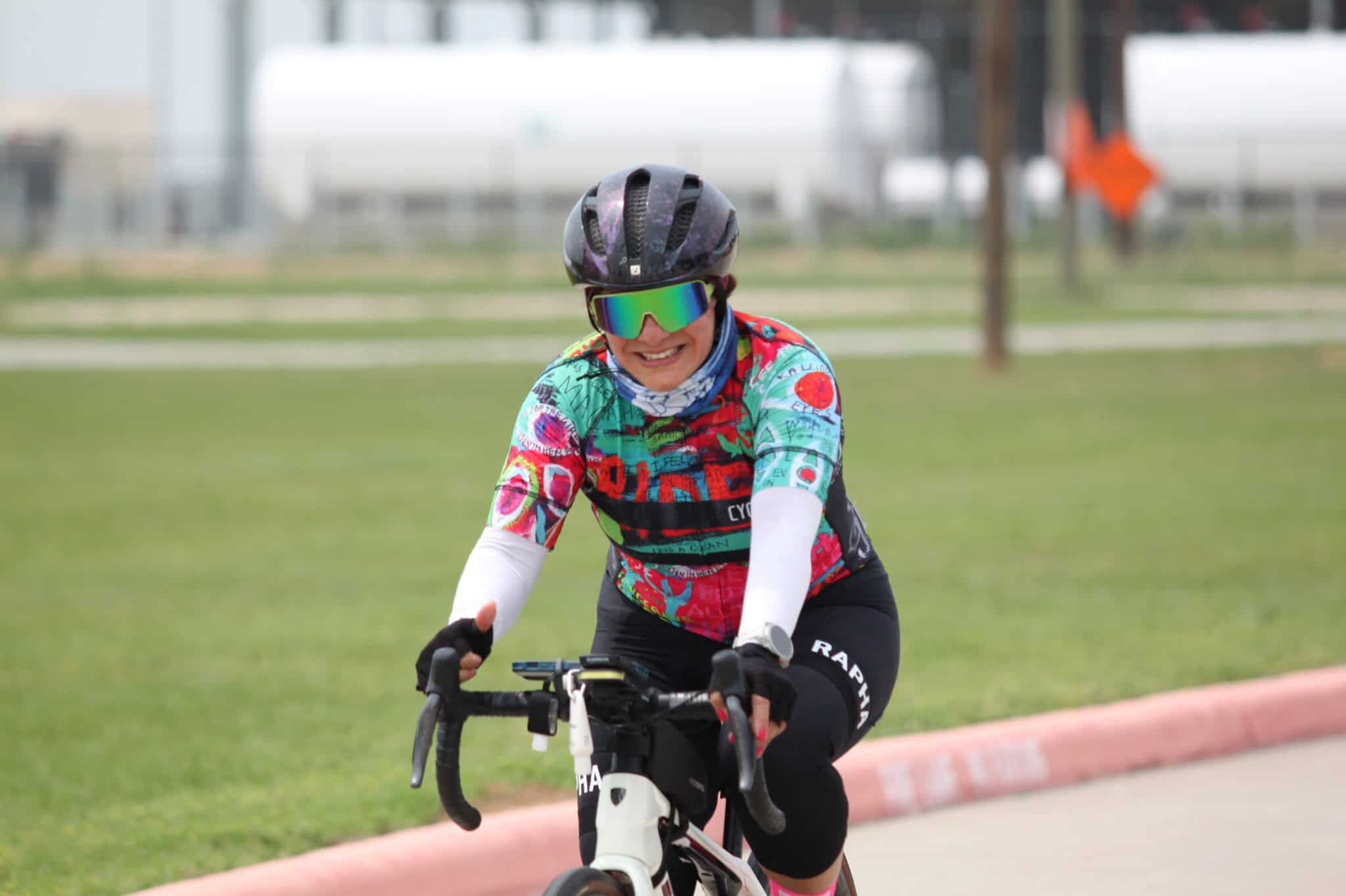 Brightly colored cyclist riding a bike outdoors during daytime.