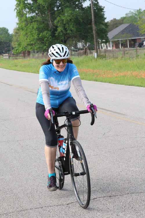 Active woman riding a bike during Bluebonnet Express event in scenic outdoor setting.