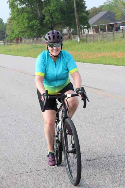Bright blue cycling jersey worn by woman riding a bike outdoors.