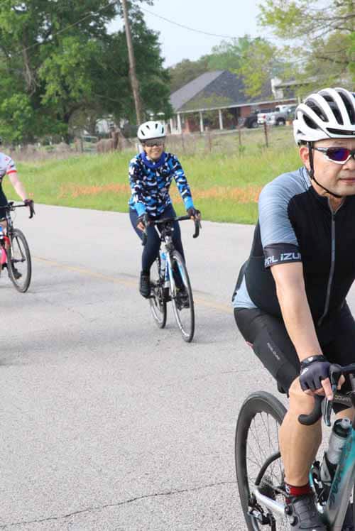 Bright cyclists enjoying a ride on a suburban road during Bluebonnet Express event.