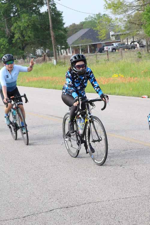 Riders cycling on a scenic road in a Bluebonnet Express community event.