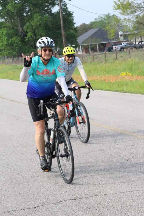 Brightly dressed cyclists enjoying a scenic bike ride along the Bluebonnet Express trail.