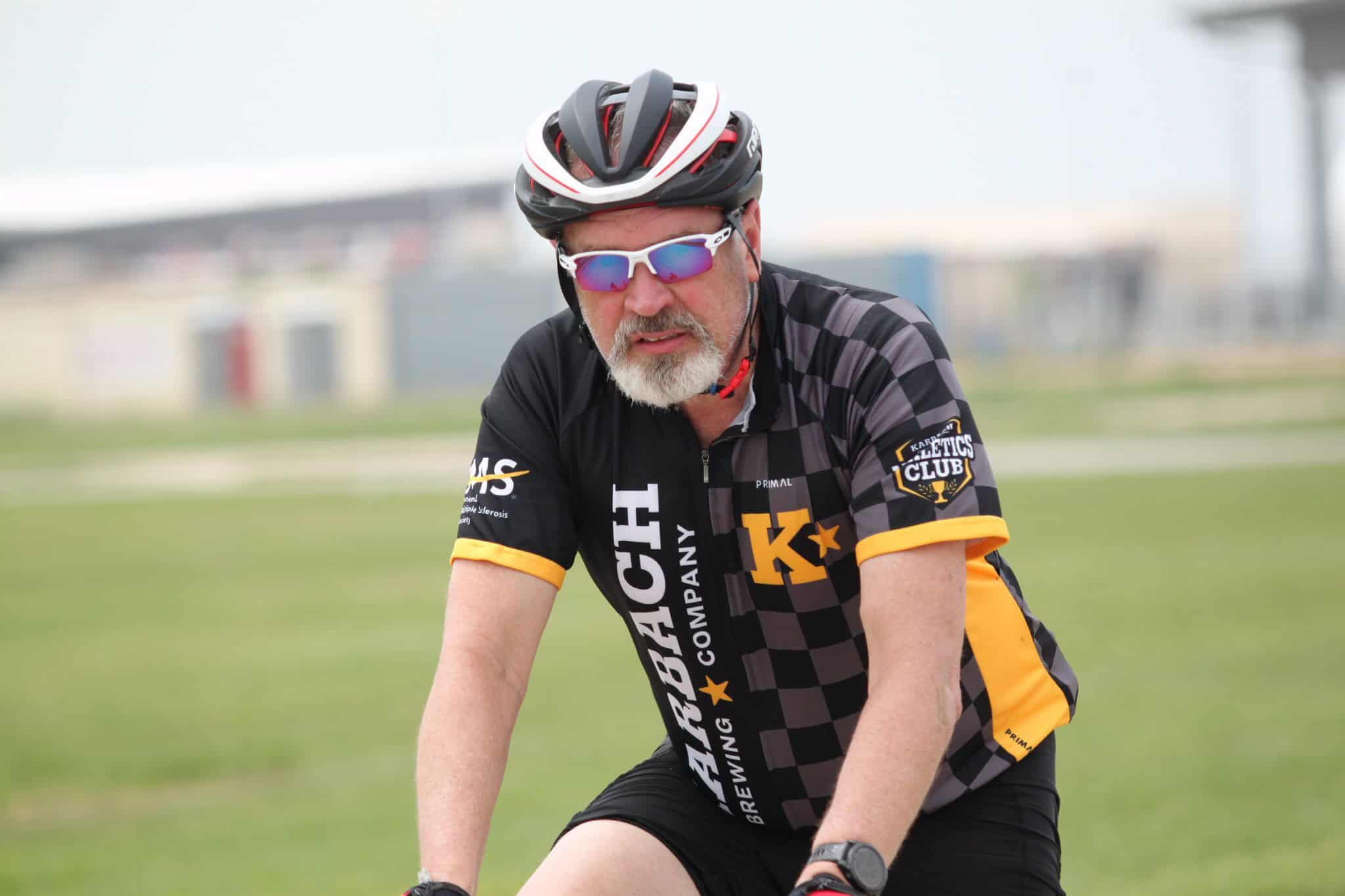 Cycling enthusiast wearing Bluebonnet Express jersey and helmet during a bike ride outdoors.