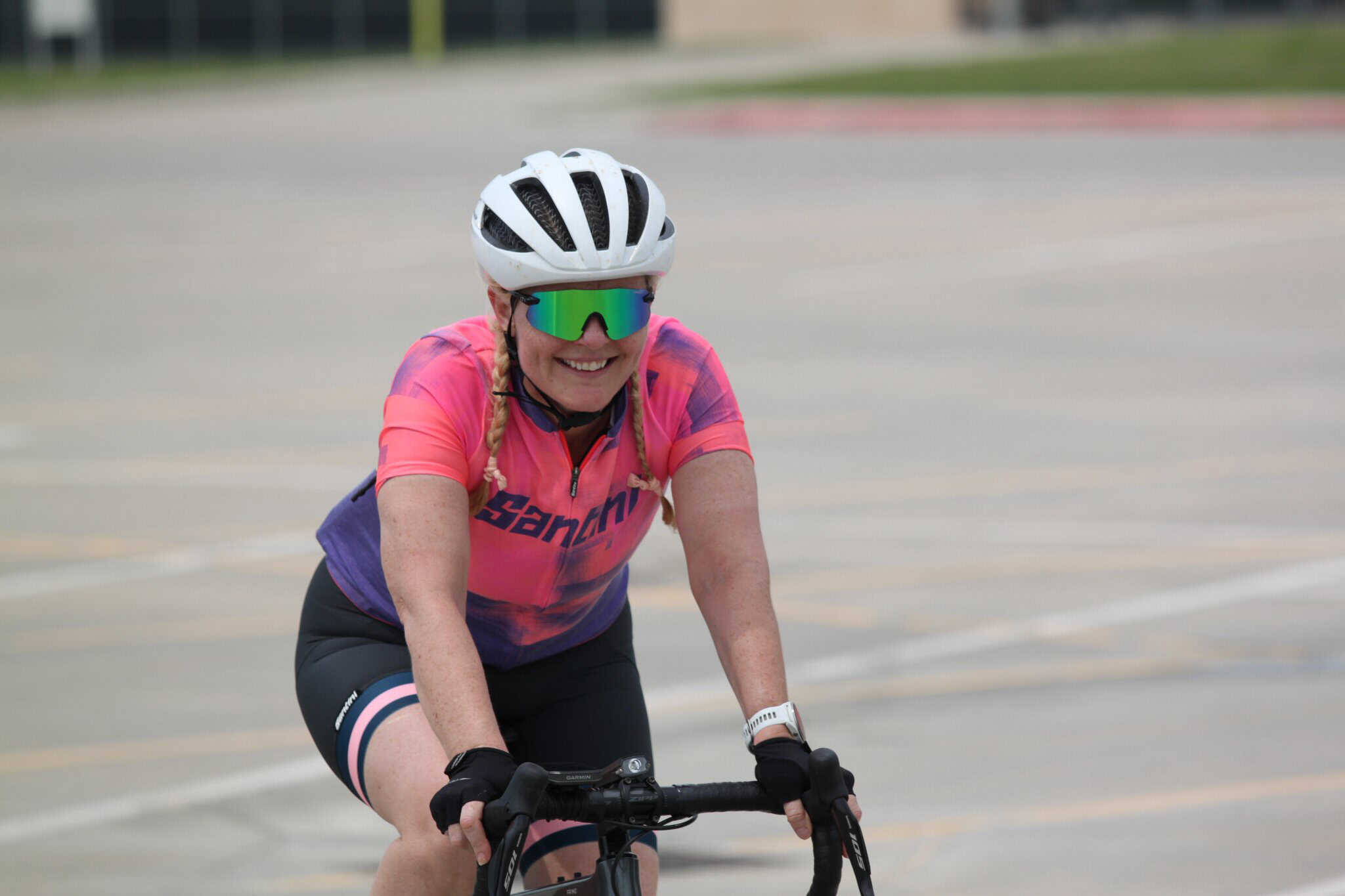 Bright female cyclist enjoying a ride on a sunny day, showcasing Bluebonnet Express cycling gear.