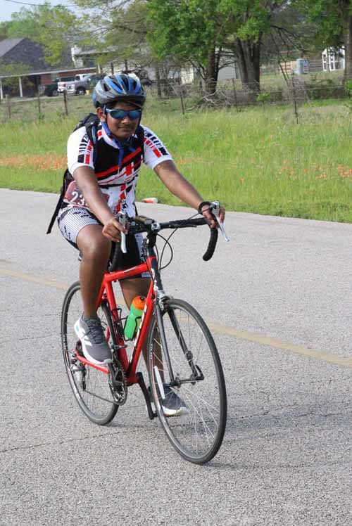 Young boy cyclist riding on the road during Bluebonnet Express cycling event.