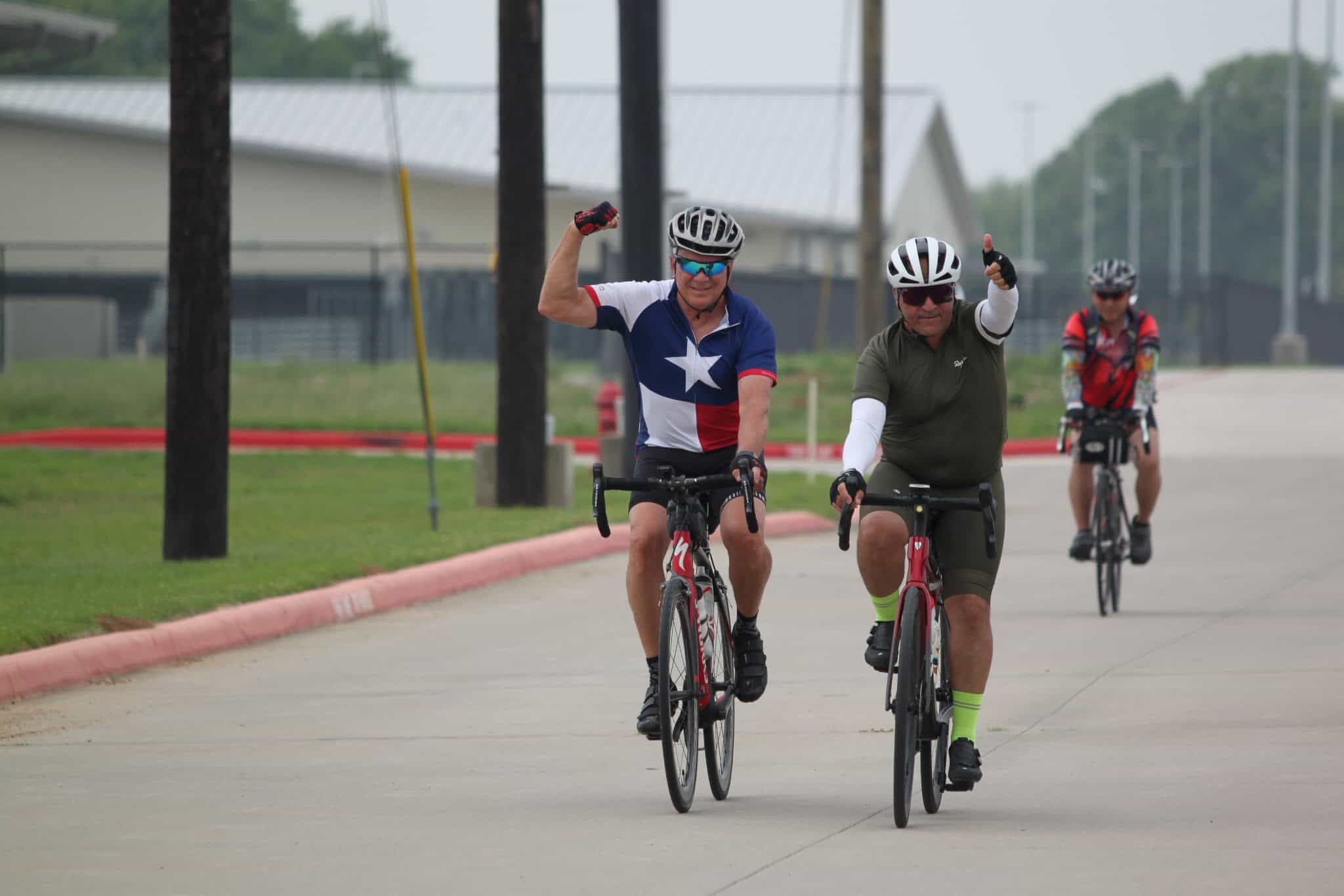 Vibrant cyclists riding electric bikes outdoors on a sunny day for Bluebonnet Express event.