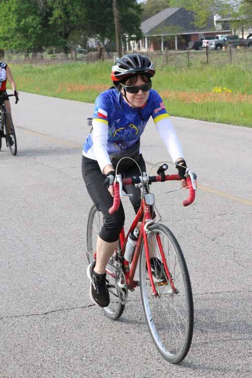 Rider in Bluebonnet Express cycling jersey riding a bike outdoors during daytime.