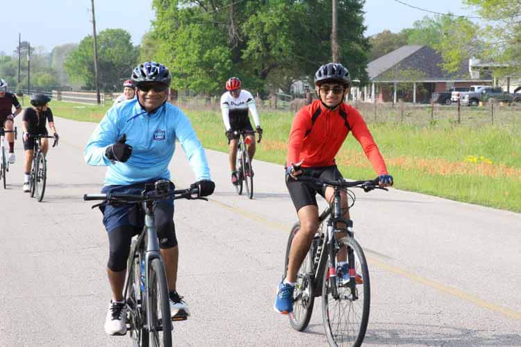 Cyclists enjoying a group ride on a scenic country road during Bluebonnet Express event.