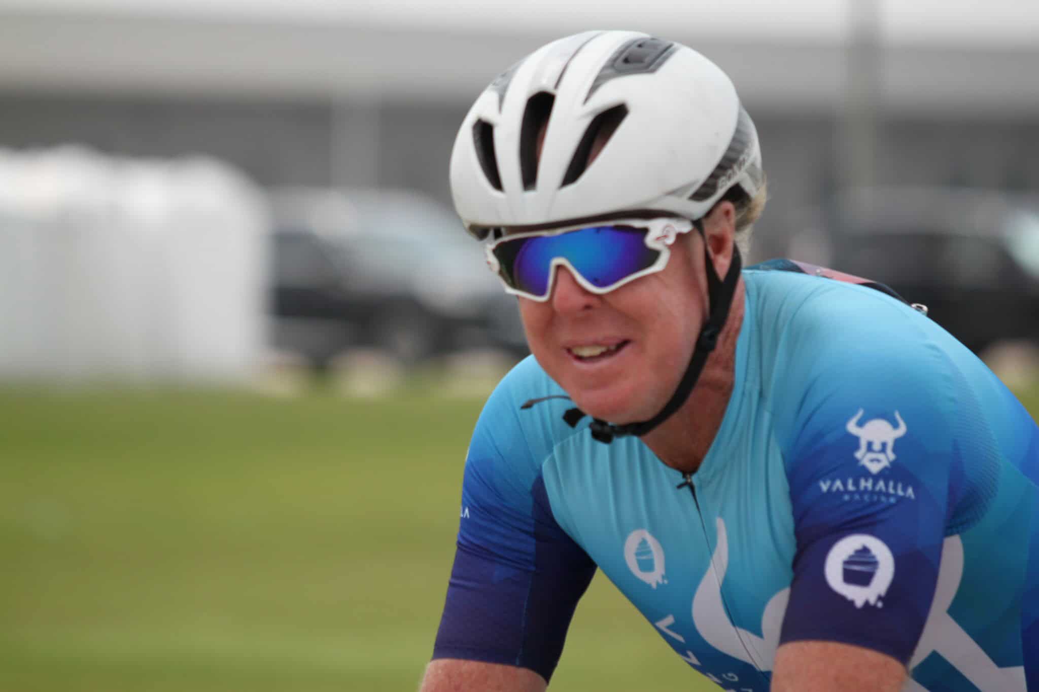Cyclist wearing a white helmet and blue sports jersey during Bluebonnet Express race.